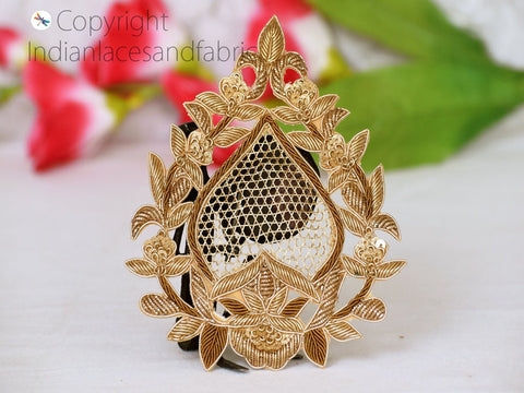 Gold Zardozi decorative patch stitched onto fabric sleeve or blouse neckline — illustrates use as garment embellishment for bridal or ethnic fashion