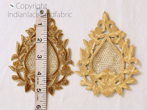 Zardozi applique floral motif displayed next to ruler for scale — approximately 2.5 to 3 inches across, with fine sequin and gold-thread embroidery