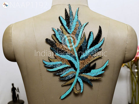 12″ feather-shaped appliqué embellished with turquoise blue, gold, and black beads and sequins—handcrafted for dramatic visual impact on garments or décor.