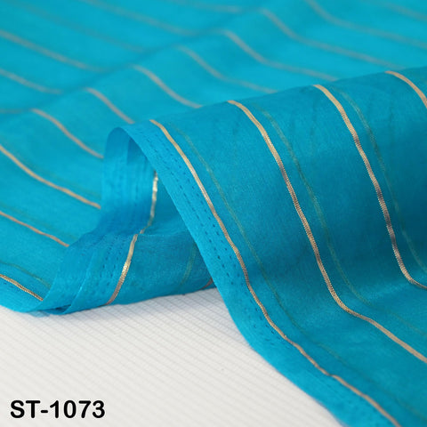Close up of Bright turquoise blue organza dupatta with vertical metallic silver zari stripes, kept neatly for a full view of its sheer and lightweight texture