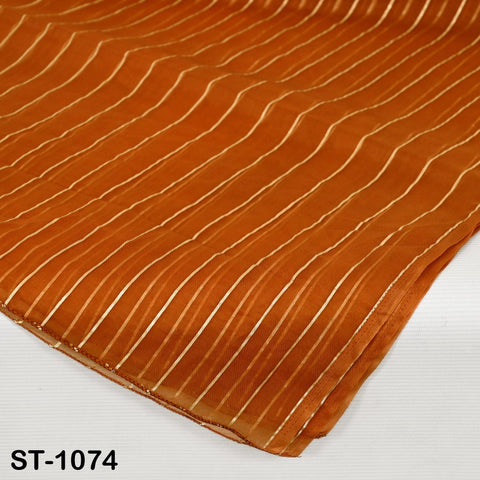 Close up of Burnt orange organza dupatta with elegant vertical gold zari stripes, styled draped over a table and hanging, showcasing its lightweight, sheer fabric and soft shimmer