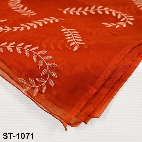 Close-up of Rust orange  organza dupatta with delicate white stitching in a botanical pattern, traditional ethnic accessory.