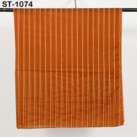 Rust orange organza dupatta with elegant vertical gold zari stripes, styled draped over a table and hanging, showcasing its lightweight, sheer fabric and soft shimmer