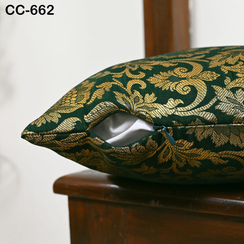 Elegant green Banarasi pillow with gold damask floral brocade displayed on marble surface.