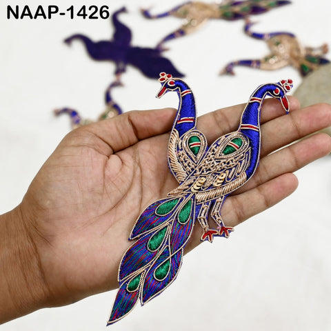 Gold peacock appliqués set displayed flat on fabric, highlighting texture, shine and traditional Indian motif in red, green, blue and white.