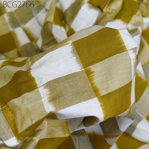 a close-up view of a fabric with a yellow and white checkered pattern. The fabric appears to be made of a material with a textured, woven appearance.