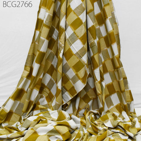 a large piece of fabric with a checkered pattern in shades of yellow and white. The fabric appears to be folded or rolled up, creating a visually interesting and textured appearance.