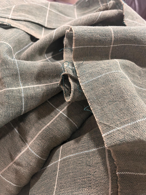 a close-up view of a fabric with a checkered pattern, featuring a mix of gray and white colors.