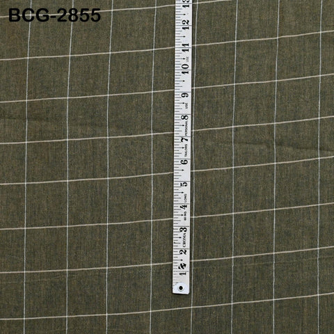 a ruler placed vertically on a fabric with a grid pattern.