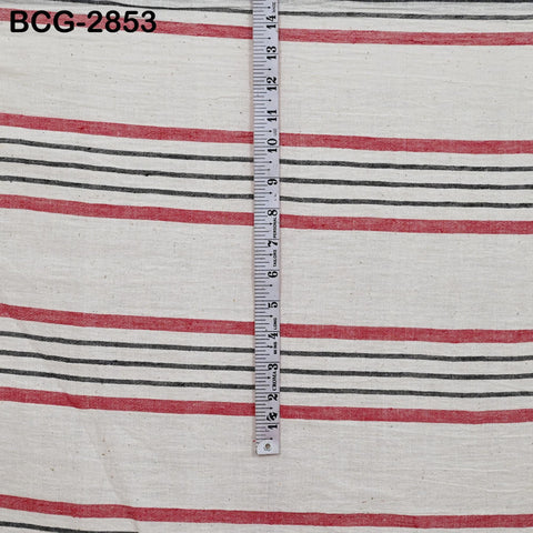 a close-up view of a fabric with horizontal red and black stripes. A ruler is placed vertically on the fabric, providing a measurement scale.