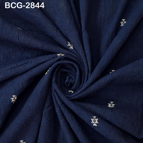 a close-up view of a dark blue fabric with small white star-like patterns or designs scattered across it.