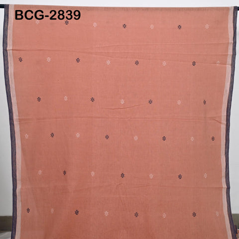 a large piece of fabric with a repeating pattern of small white and black dots or stars on a peach-colored background.