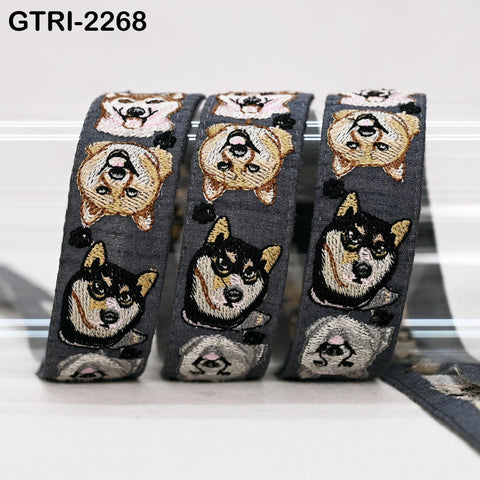 A close-up image of a gray fabric with a repeating pattern of embroidered dog faces in various poses and expressions.