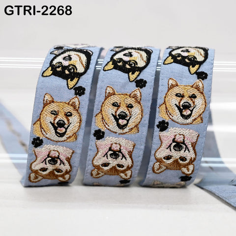 three blue fabric ribbons with a repeating pattern of cartoon dog faces on them.