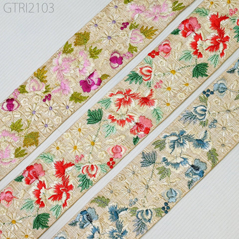 three horizontal fabric strips with intricate floral embroidery designs in various colors, including pink, red, green, and blue.