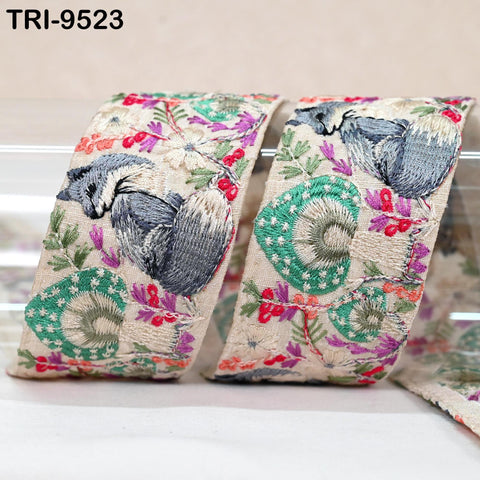 two pieces of fabric with a floral pattern, including a gray cat and various colorful flowers and leaves.