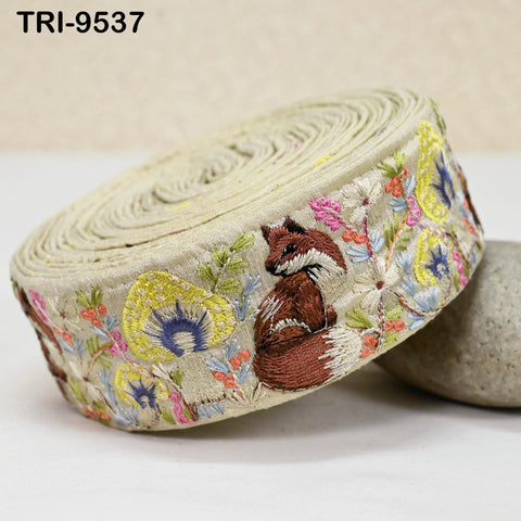 a decorative fabric with a fox embroidered on it, placed on a white surface.