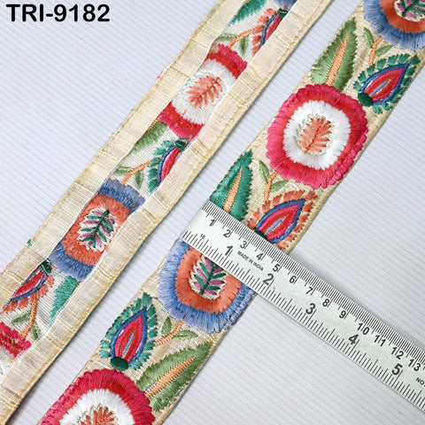 a close-up view of a decorative fabric with a floral pattern, featuring a ruler for scale.