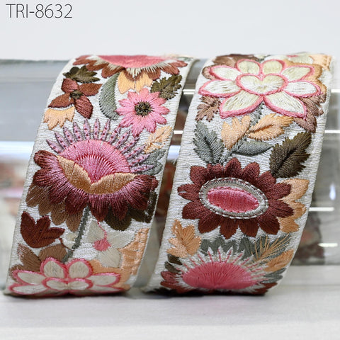 two decorative fabric pieces with intricate floral embroidery in shades of pink, green, and brown.