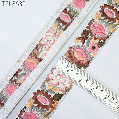 a close-up view of a decorative fabric with a floral pattern, featuring a ruler for scale.