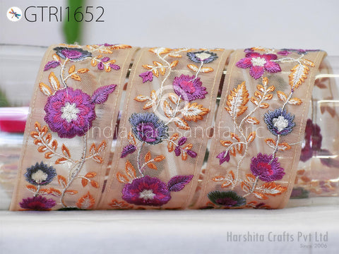 three rolls of embroidered fabric with intricate floral designs in shades of purple, orange, and white.