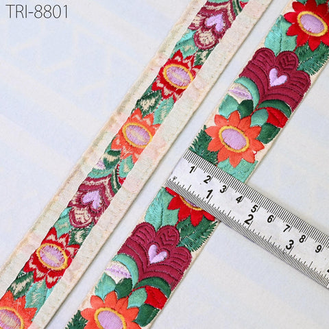 a close-up view of a decorative fabric with a floral pattern, featuring a ruler for scale.