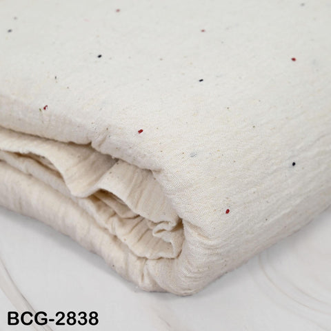 A close-up image of a white fabric with small red and black dots on it.