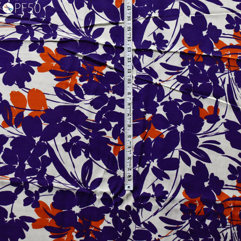 a close-up view of a fabric with a floral pattern in shades of purple and orange. The fabric appears to be wrinkled, and there is a ruler visible in the image.
