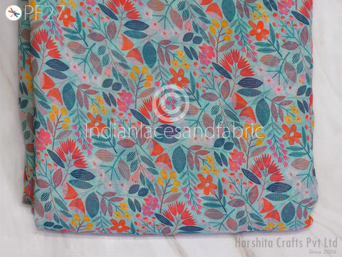 a close-up view of a fabric with a vibrant floral pattern in shades of blue, green, orange, and pink. The pattern is composed of various flowers and leaves, creating a visually appealing and colorful design.