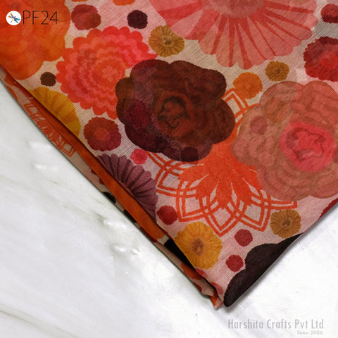 a close-up view of a colorful fabric with a floral pattern, including various shades of orange, pink, and red.