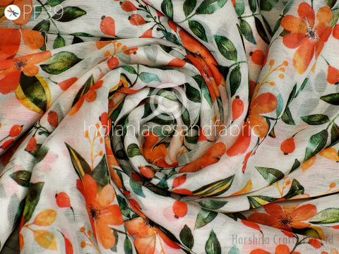 The image is a close-up of a fabric with a floral pattern, featuring orange and green leaves and flowers. The fabric appears to be white and has a textured appearance.