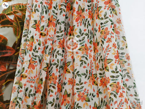 a close-up view of a fabric with a floral pattern in shades of orange and green.