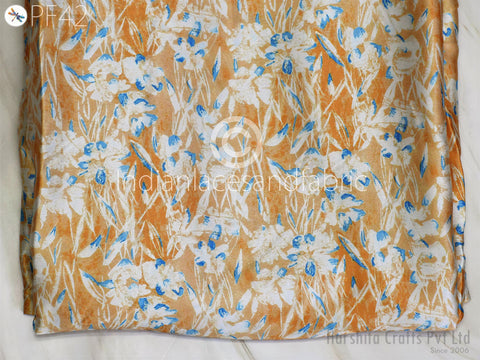 a close-up view of a fabric with a floral pattern in shades of orange and white. The fabric appears to be a piece of clothing or textile with a printed design.