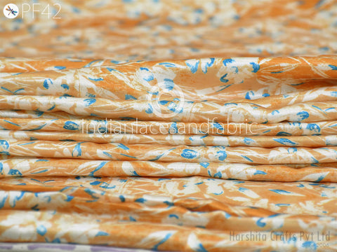 A close-up image of a fabric with a floral pattern in shades of orange and blue.