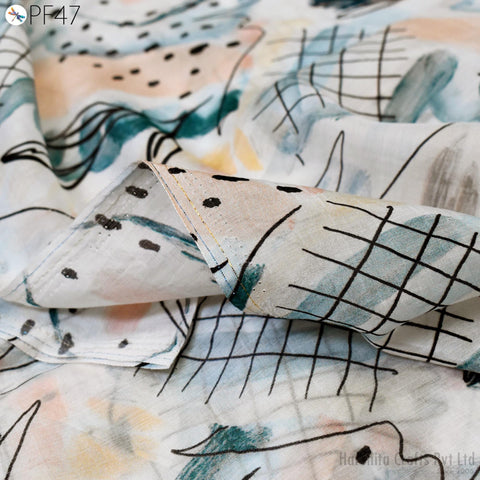 a close-up view of a fabric with a geometric pattern, featuring a mix of lines, dots, and other abstract shapes. The fabric appears to be a piece of clothing or textile, with a textured and colorful appearance.