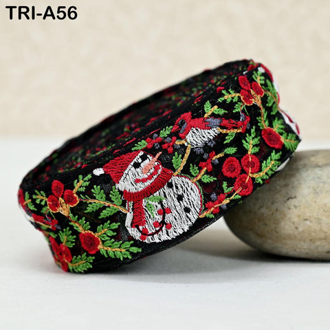 A decorative fabric with a snowman design and red flowers, sitting on a white surface.