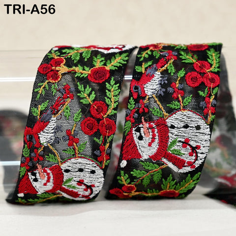 two pieces of fabric with a festive, holiday-themed design. The fabric has a black background with red and green floral and snowman motifs, as well as red flowers. The text "TRI-A56" is visible in the image.