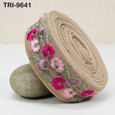 a beige fabric with a floral design, including pink and purple flowers, arranged in a circular pattern.