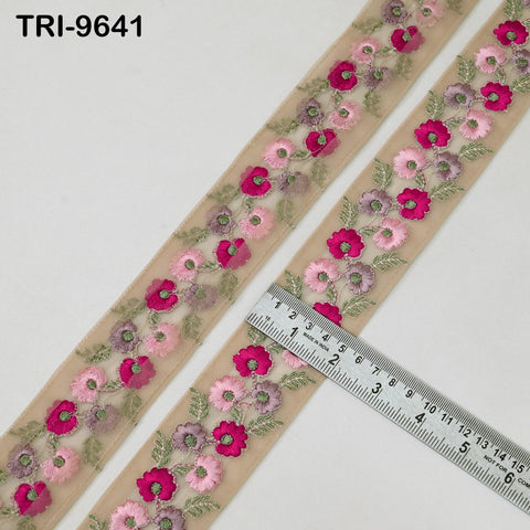 a decorative fabric with a floral pattern, featuring pink and purple flowers arranged in a repeating pattern. A ruler is placed next to the fabric, indicating the size or length of the fabric.