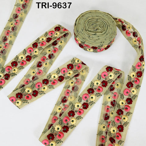 a collection of decorative fabric pieces, including a spool of thread with a floral pattern and several pieces of fabric with a similar floral design.