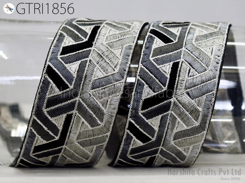 two decorative fabric pieces with a geometric pattern in shades of gray and black.