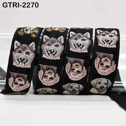 A group of black and white embroidered dog faces on a black background, arranged in a row.