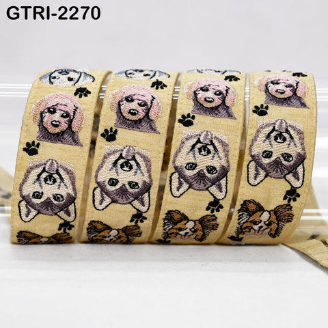 a collection of yellow fabric ribbons with various animal faces and paw prints printed on them.