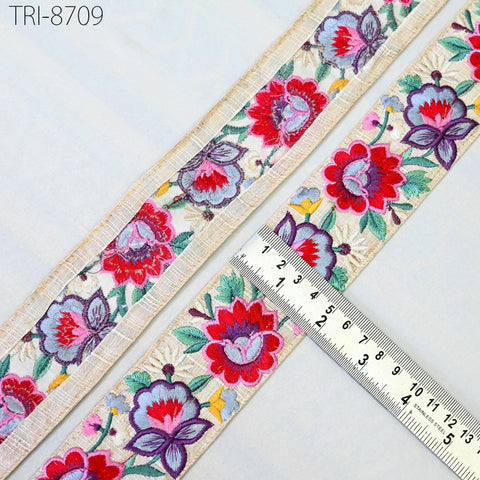 a decorative fabric with a floral pattern, featuring a ruler placed on top of it to measure the length.