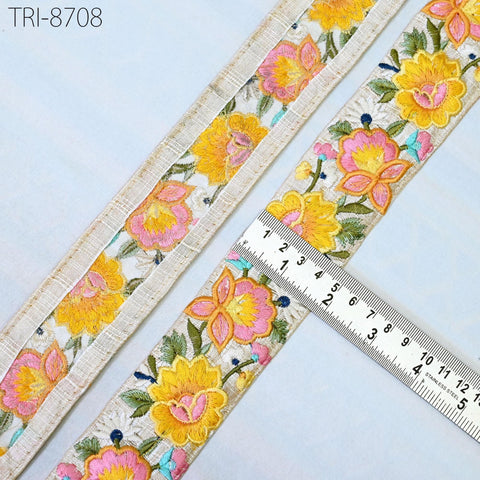 a close-up view of a decorative fabric with a floral pattern, featuring yellow and pink flowers. A ruler is placed next to the fabric, indicating the size of the fabric.