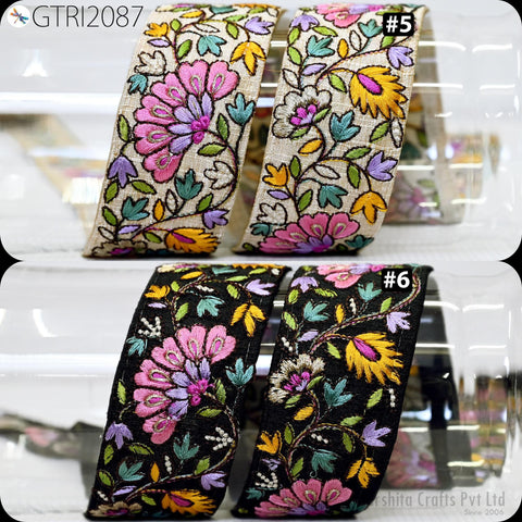 a collection of colorful, intricately embroidered fabric pieces, including a floral pattern and a black and yellow floral pattern. The pieces are arranged in a visually appealing manner, showcasing the detailed craftsmanship of the embroidery.