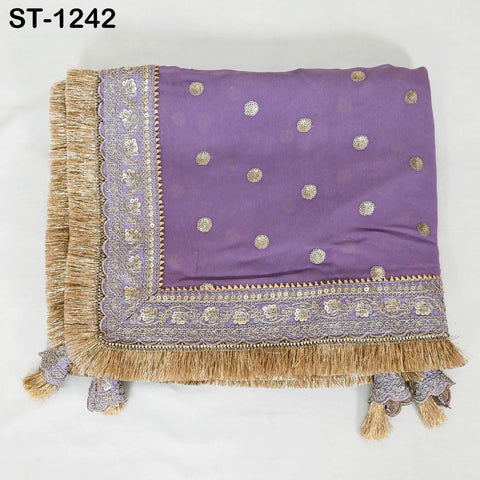 a purple fabric with gold and white polka dot patterns, adorned with a decorative border and fringe.