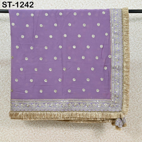 a purple fabric with a polka dot pattern, hanging on a rack. The fabric has a fringe trim and is embellished with gold and silver sequins.