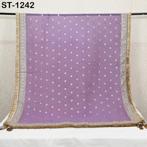 a purple and gold decorative fabric with a polka dot pattern, hanging on a rod.