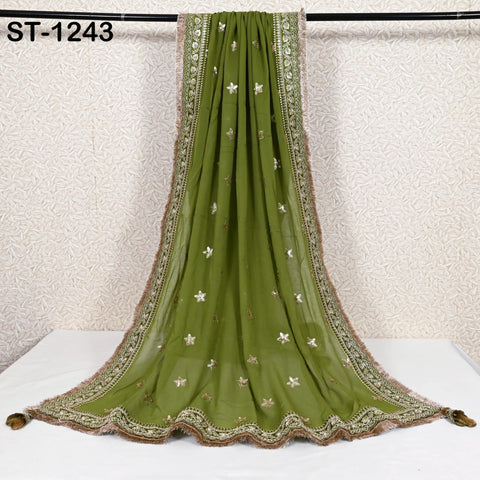 a green and gold embroidered shawl hanging on a black rod.